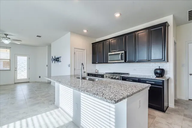 a kitchen with a sink a microwave and cabinets
