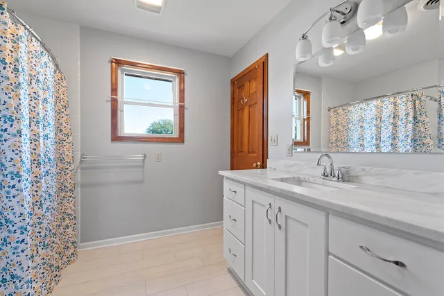 a view of an empty room with a cabinet and a window