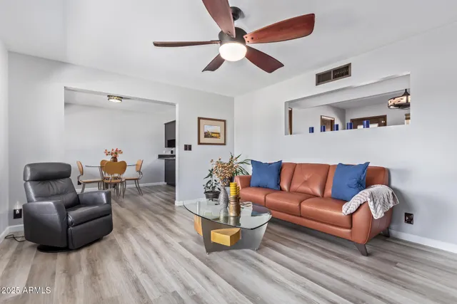 a living room with furniture and a wooden floor