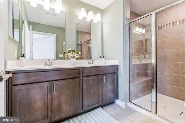 a bathroom with a double vanity sink mirror and shower