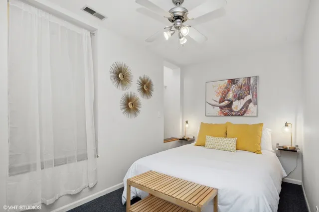 a bedroom with a bed and a painting on the wall