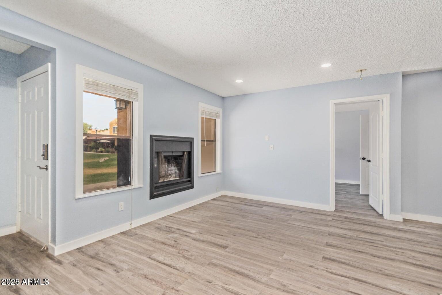 3511 East Baseline Road, Unit 1216 Phoenix, AZ 85042 - Photo 10 of 11 a view of an empty room with wooden floor fireplace and a window