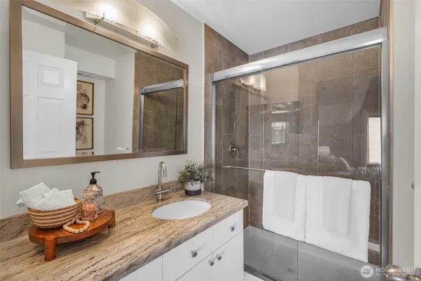 a bathroom with a granite countertop sink and a mirror