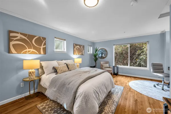 a spacious bedroom with a bed and a dresser next to a window