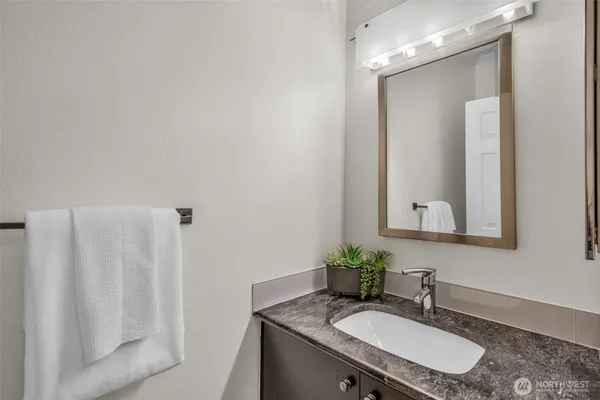 a bathroom with a granite countertop sink and a mirror