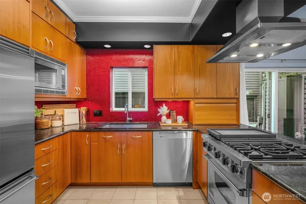 a kitchen with stainless steel appliances granite countertop a sink stove and refrigerator