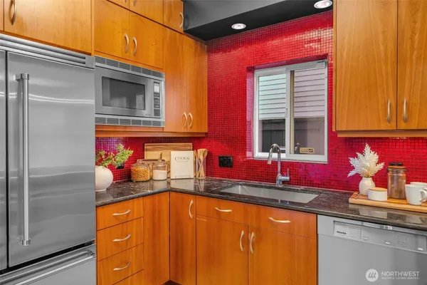 a view of a kitchen with stainless steel appliances granite countertop a sink and cabinets