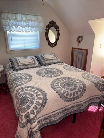 a bedroom with a bed and a dresser with wooden floor