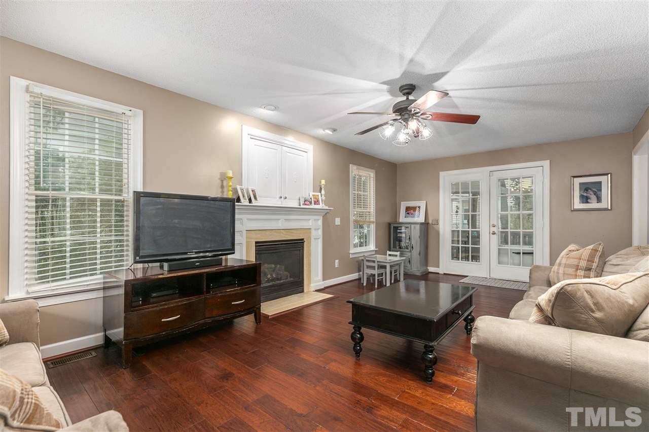 5105 Knightsbridge Way Raleigh, NC 27604 - Photo 4 of 25 a living room with furniture a fireplace and a flat screen tv