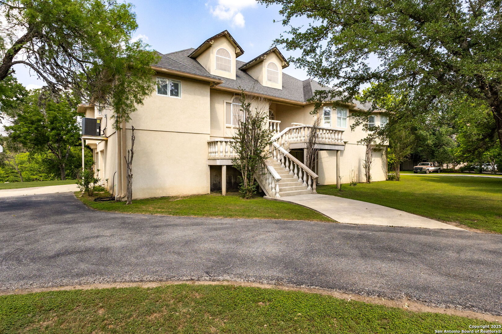 a view of a house with a yard and large tree