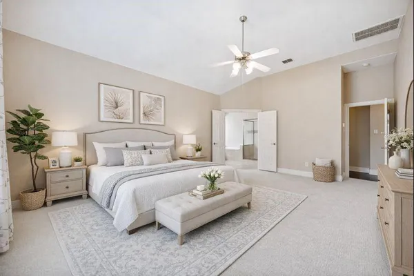 a spacious bedroom with a bed and a chandelier