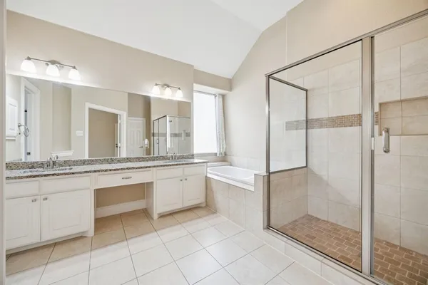 a bathroom with a granite countertop sink mirror and bathtub