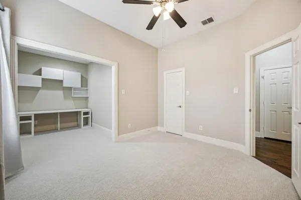 a view of an empty room with cabinet and a window