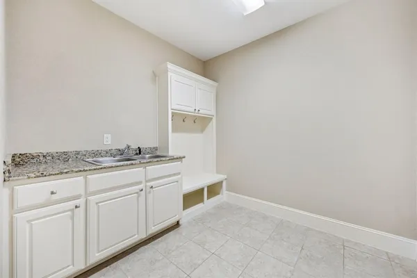 a bathroom with a granite countertop sink and white cabinets