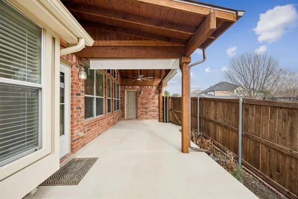 a view of backyard with large trees and wooden fence