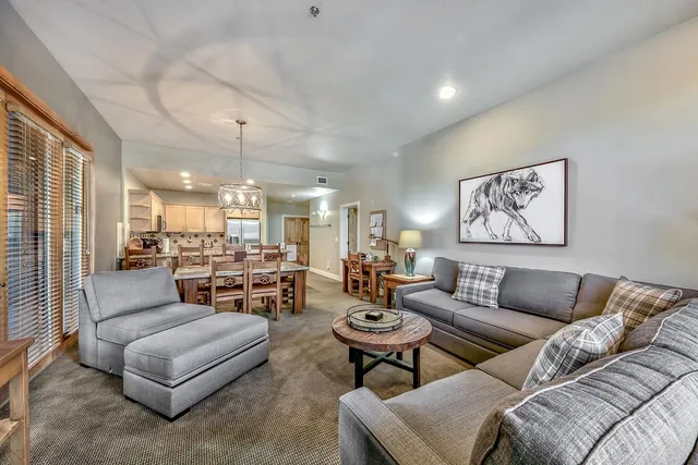 a living room with furniture and a chandelier