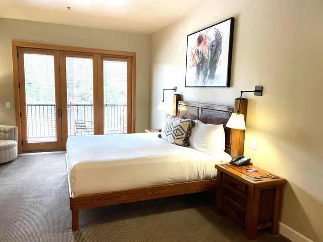 a bedroom with a bed wooden floor and window