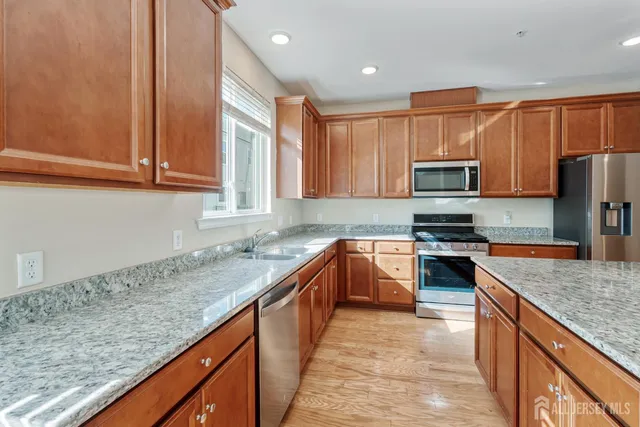 a kitchen with stainless steel appliances granite countertop a sink stove and microwave