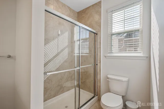 a bathroom with a toilet and a shower