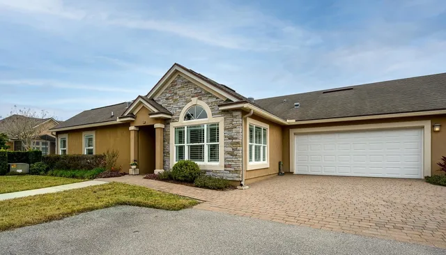 a front view of a house with a garden and garage