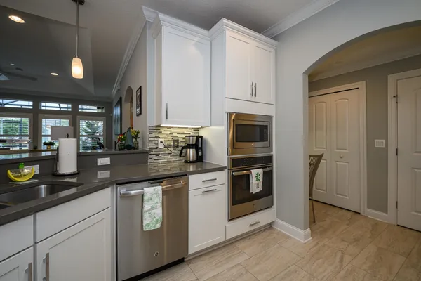 a kitchen with white cabinets and stainless steel appliances