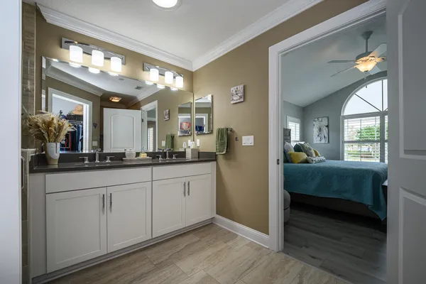 a white bath tub sitting next to a white sink and vanity