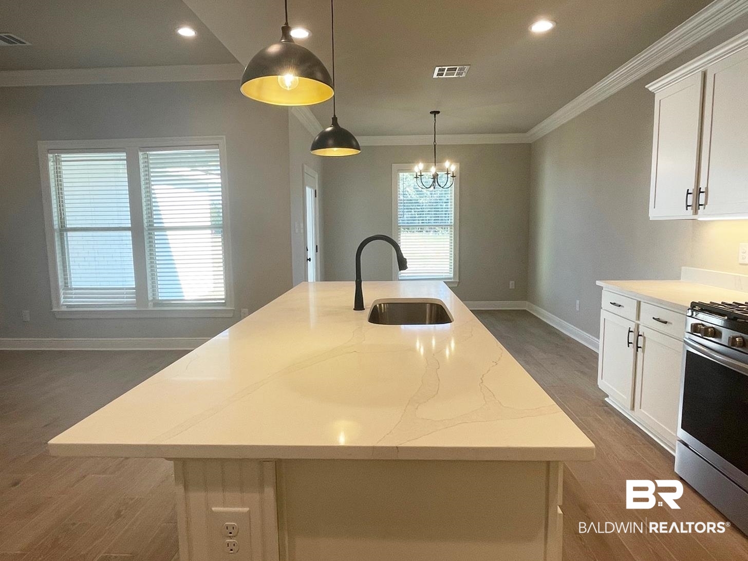 1392 Fenton Circle Foley, AL 36535 - Photo 3 of 17 Kitchen featuring white cabinets, light stone counters, sink, and an island with sink