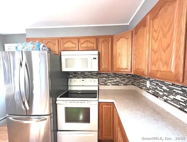 a kitchen with a refrigerator and wooden floor