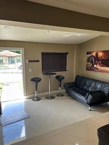 a living room with furniture a flat screen tv and a window