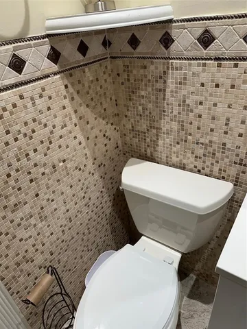 a white toilet sitting next to a bathroom sink