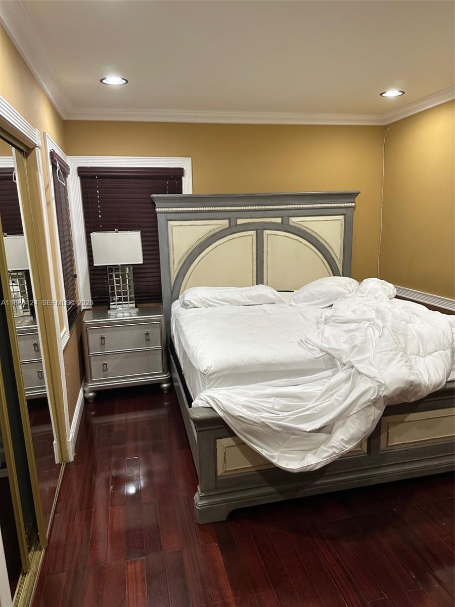 1619 Northwest 52nd Street, Unit 1 Miami, FL 33142 - Photo 15 of 16 a bedroom with a bed and wooden floor