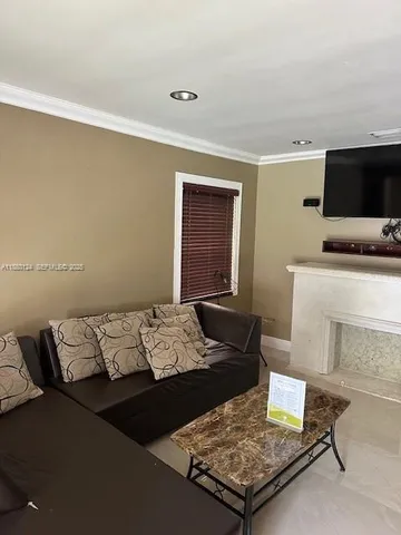 a living room with a bed and a flat screen tv