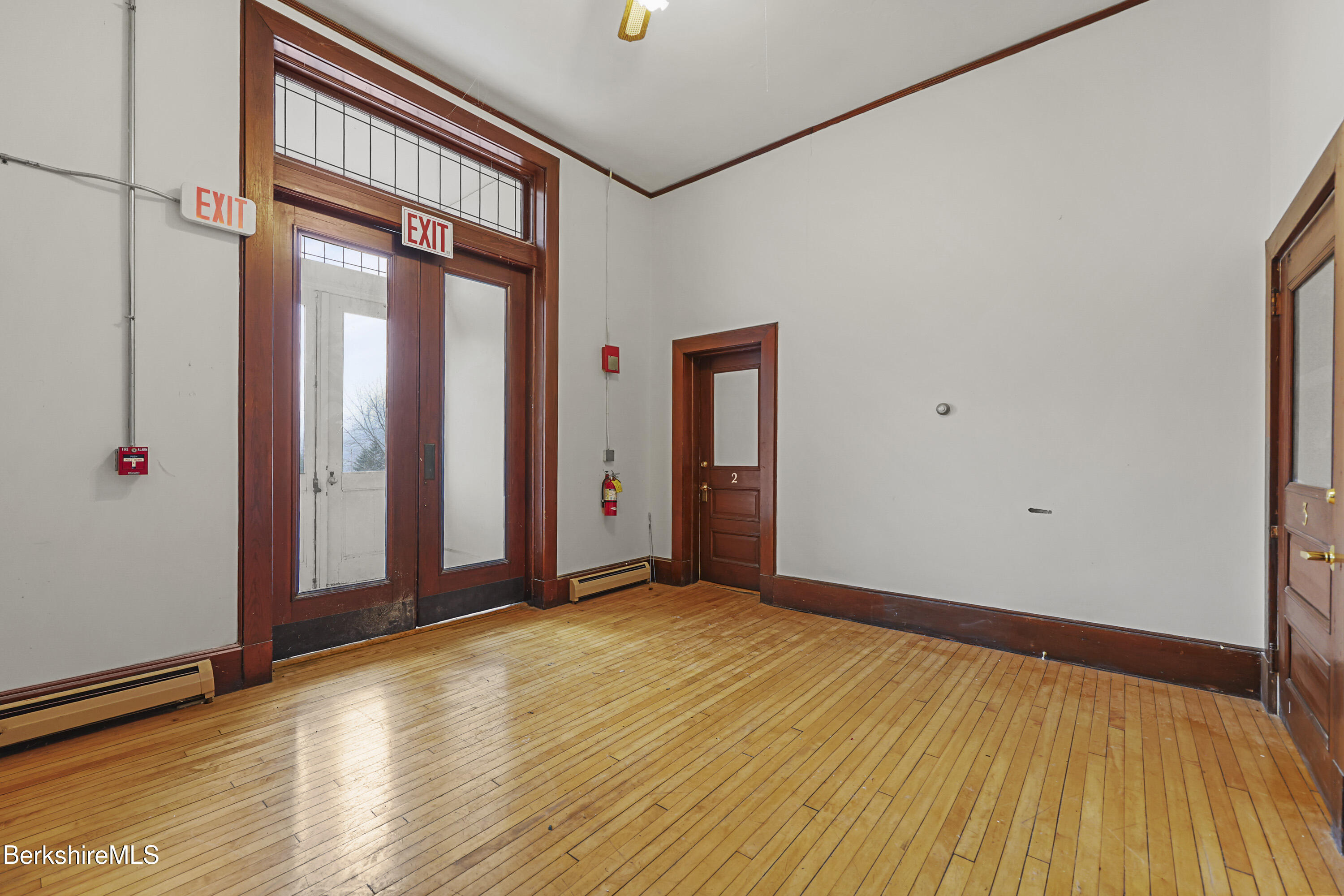 55 Crystal Street, Unit 8 Lenox, MA 01242 - Photo 2 of 12 a view of an empty room with wooden floor and a window