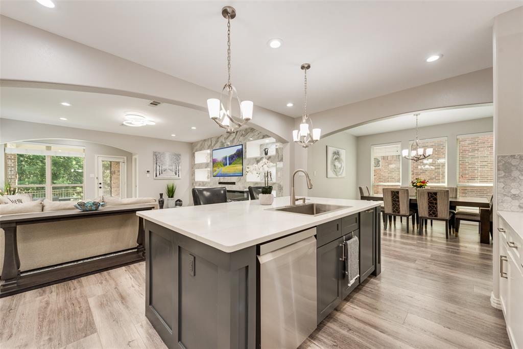 920 Sheldon Road Argyle, TX 76226 - Photo 7 of 36 Kitchen island featuring a stainless steel sink, gooseneck faucet, and integrated dishwasher
