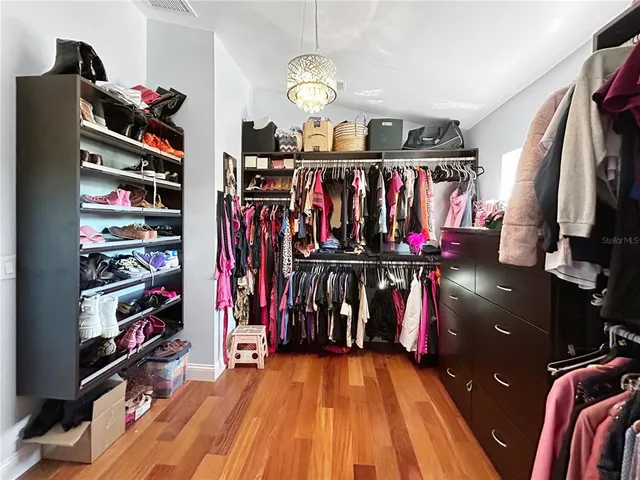 a view of walk in closet with clothes and shoes