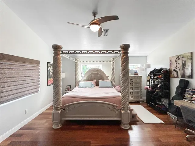 a bedroom with a bed and wooden floor