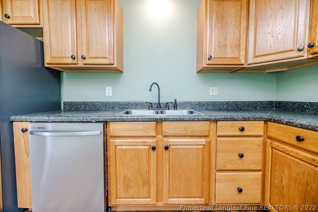 192 Cypress Road Cameron, NC 28326 - Photo 13 of 26 a kitchen with granite countertop cabinets and white appliances