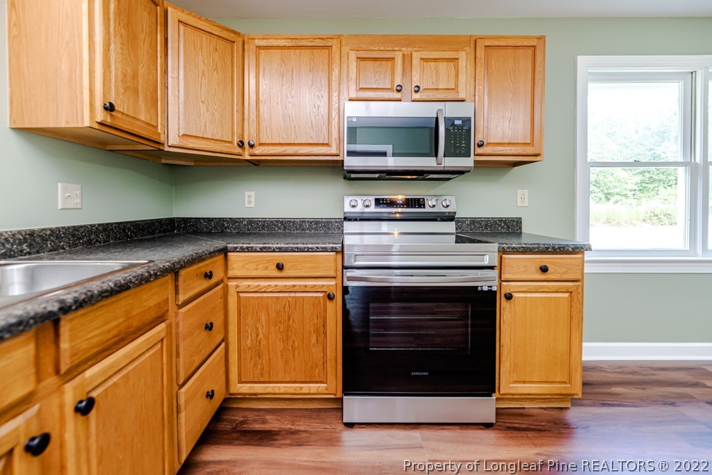 192 Cypress Road Cameron, NC 28326 - Photo 8 of 26 a kitchen with stainless steel appliances granite countertop a stove and a microwave