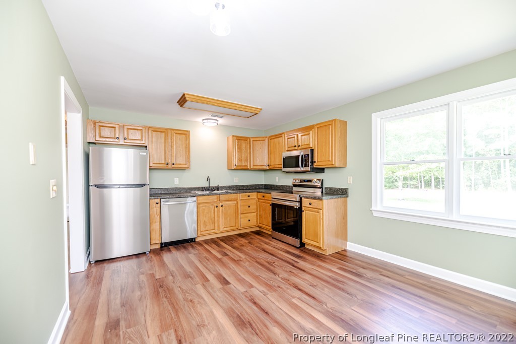 192 Cypress Road Cameron, NC 28326 - Photo 10 of 26 a kitchen with granite countertop a refrigerator and wooden floor