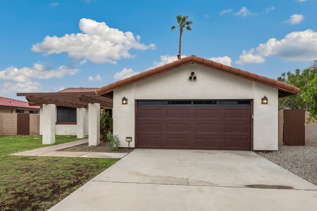 67425 Medano Road Cathedral City, CA 92234 - Photo 2 of 17 a front view of a house with a yard and garage