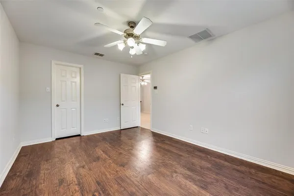 a view of an empty room with wooden floor