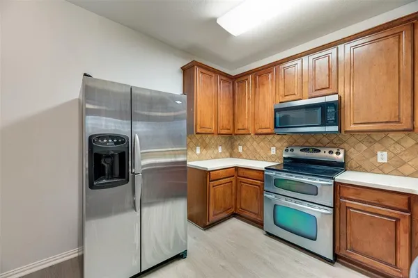 a kitchen with stainless steel appliances granite countertop a refrigerator stove and sink