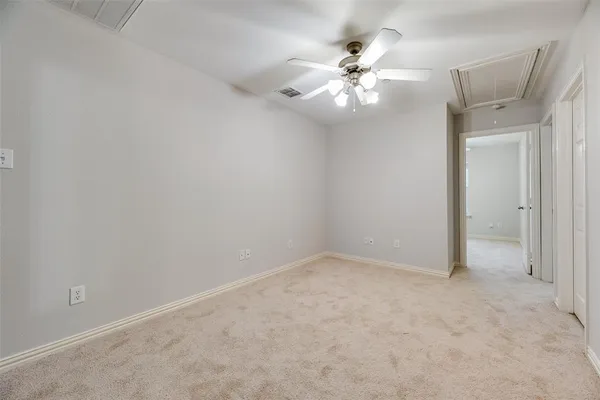 an empty room with a chandelier fan
