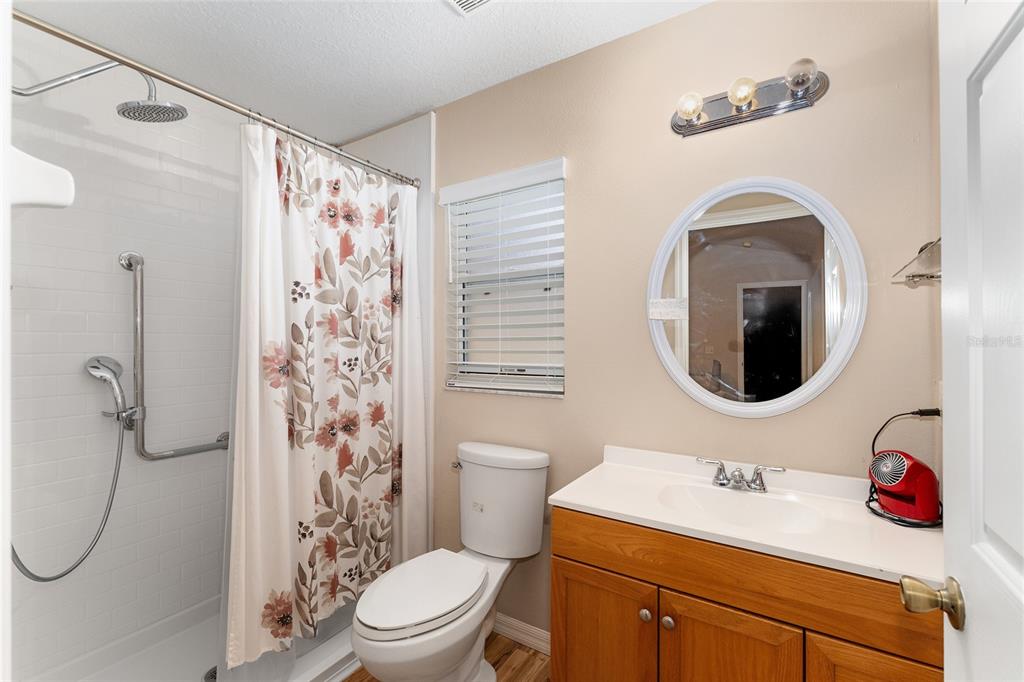 2121 Vindale Road Tavares, FL 32778 - Photo 24 of 37 a bathroom with a toilet sink vanity shower and mirror