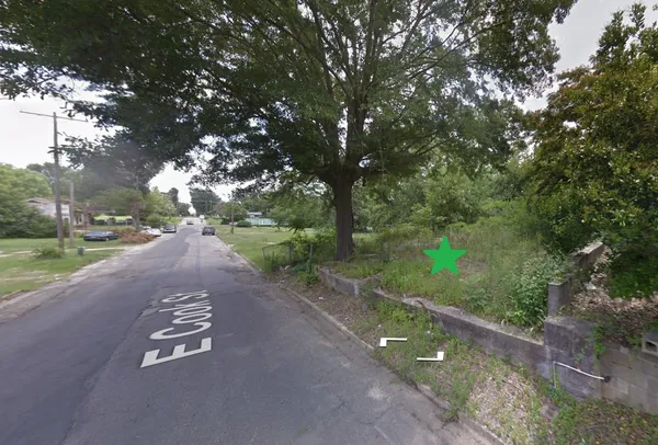 a view of a street with a yard and a trees