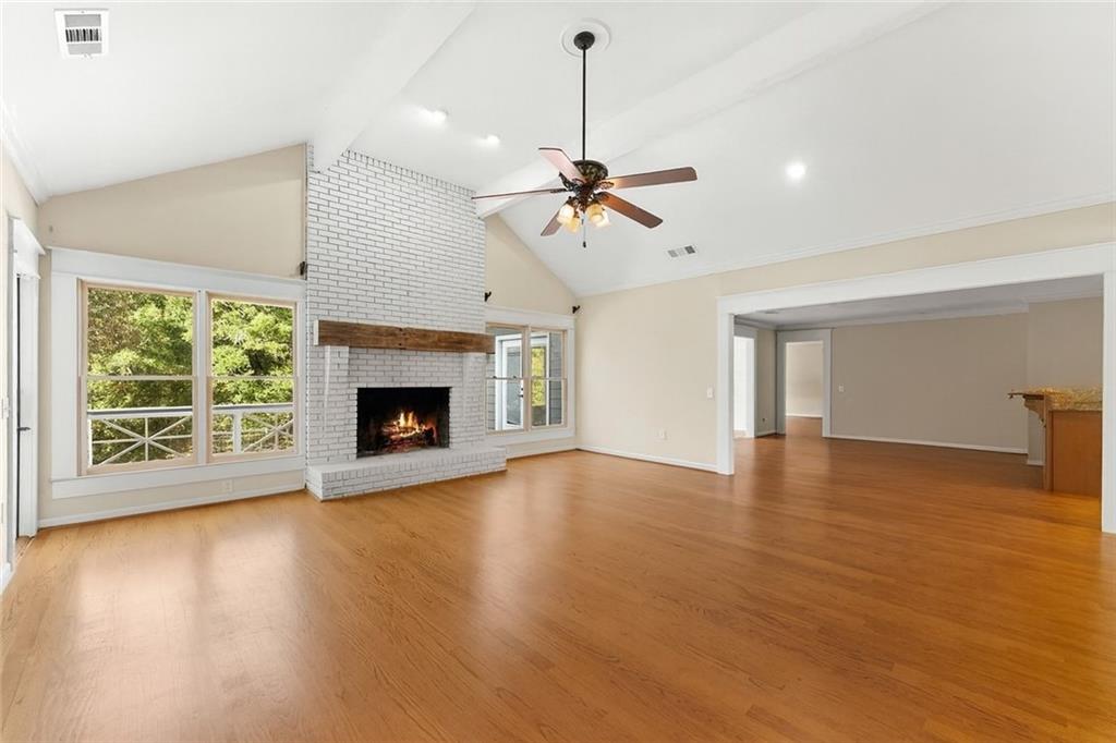 749 Hubert Pittman Road Pendergrass, GA 30567 - Photo 8 of 49 a view of an empty room with wooden floor fireplace and a window