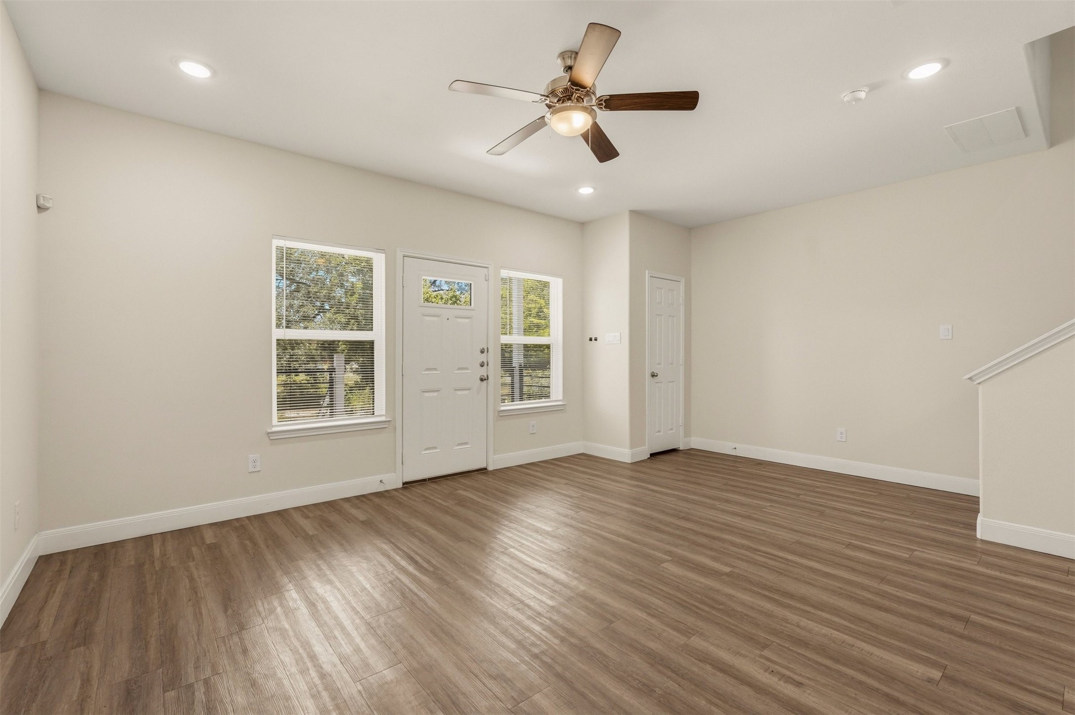 2218 Bringhurst Street, Unit B Houston, TX 77026 - Photo 5 of 25 an empty room with wooden floor chandelier fan and windows