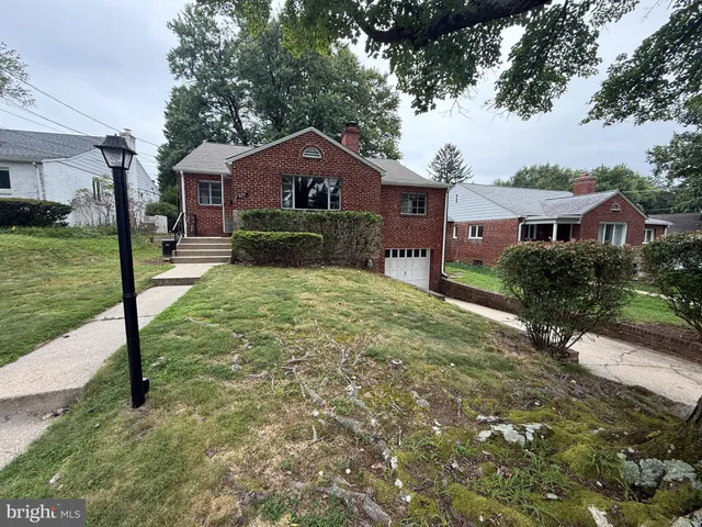 a front view of a house with yard and green space