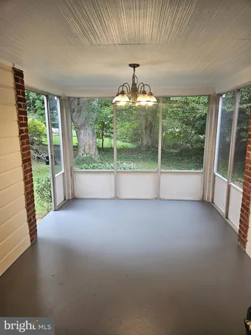 a view of a porch with furniture and floor to ceiling window