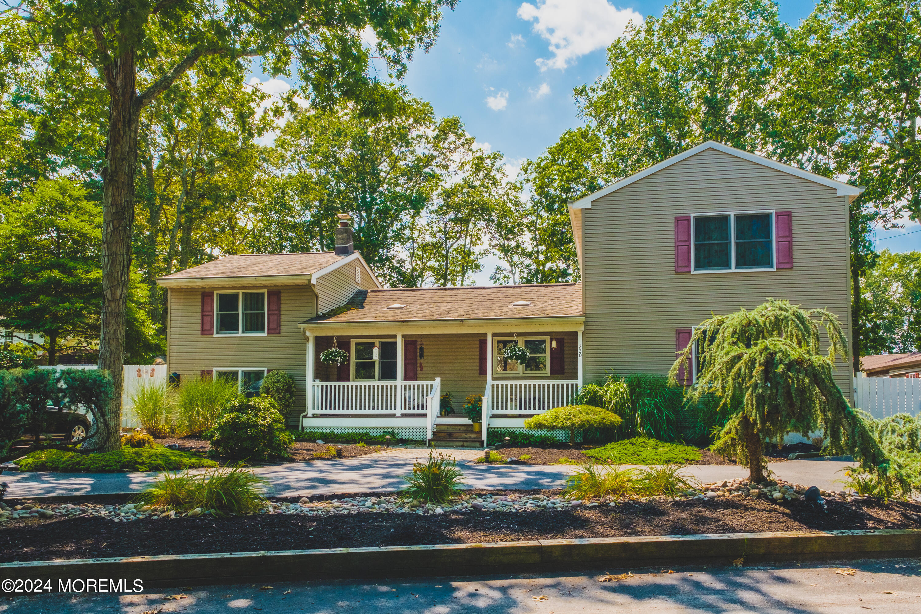 a front view of a house with a yard and potted plants